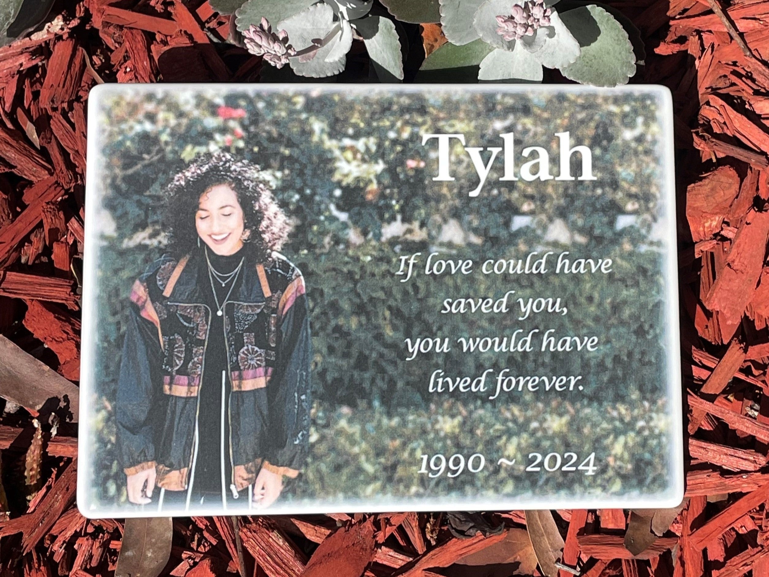 Ceramic memorial plaque with a photo of a woman in a garden and text about Tylah, weather-proof and UV-stable, suitable for indoors or outside