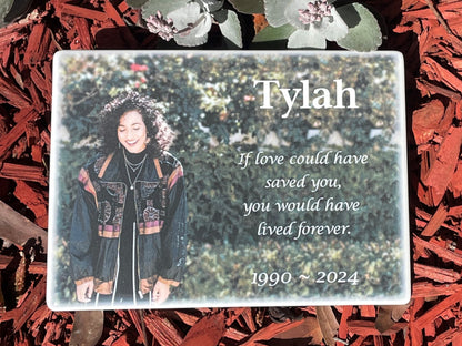 Ceramic memorial plaque with a photo of a woman in a garden and text about Tylah, weather-proof and UV-stable, suitable for indoors or outside